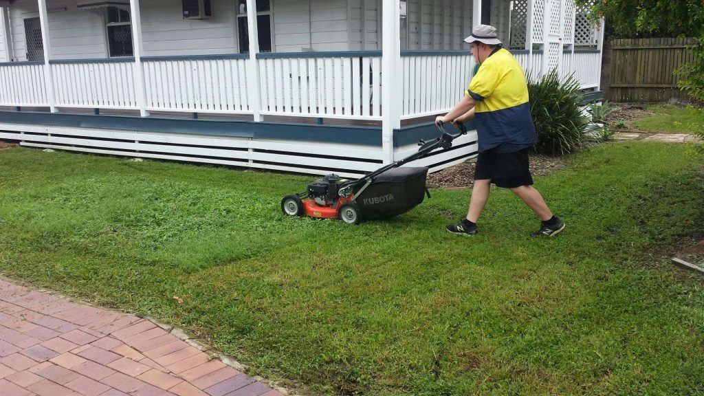 Plant-EM team member mowing lawn in Townsville